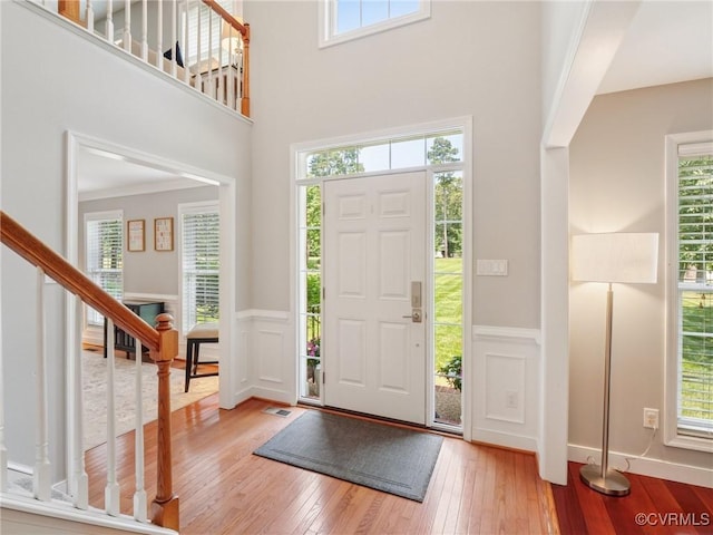 13625 Brandy Oaks Rd, Chesterfield, VA 23832 - foyer entrance featuring light wood finished floors, stairway, a wainscoted wall, a decorative wall, and a high ceiling