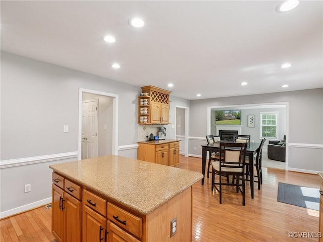 13625 Brandy Oaks Rd, Chesterfield, VA 23832 - kitchen with a kitchen island, light wood-style floors, open shelves, recessed lighting, and light stone counters