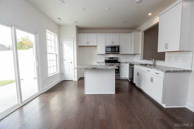 6419 Belay Dr, Chesterfield, VA 23234 - kitchen with stainless steel appliances, a kitchen island, tasteful backsplash, and dark wood finished floors