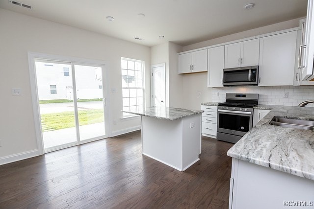 6407 Belay Dr, Chesterfield, VA 23234 - kitchen with appliances with stainless steel finishes, tasteful backsplash, light stone counters, dark wood-style floors, and white cabinets