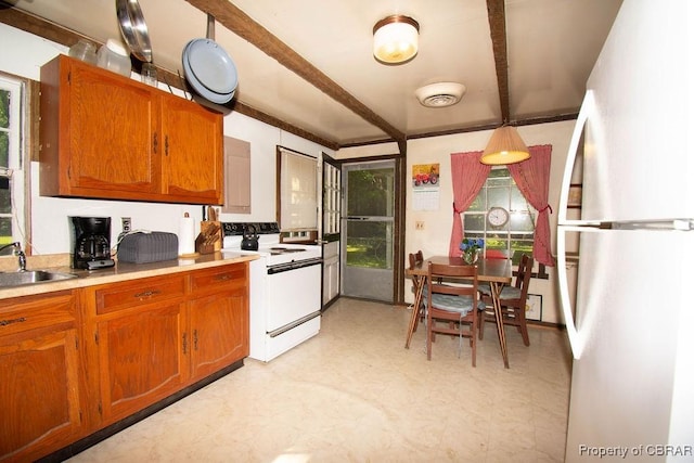 1026 Hoecake Rd, Lancaster, VA 22513 - kitchen with white appliances, light floors, brown cabinets, light countertops, and beam ceiling