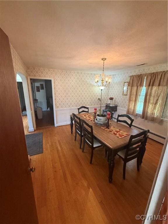 305 Danray Dr, Henrico, VA 23227 - dining space featuring wallpapered walls, a wainscoted wall, light wood-style floors, a chandelier, and arched walkways