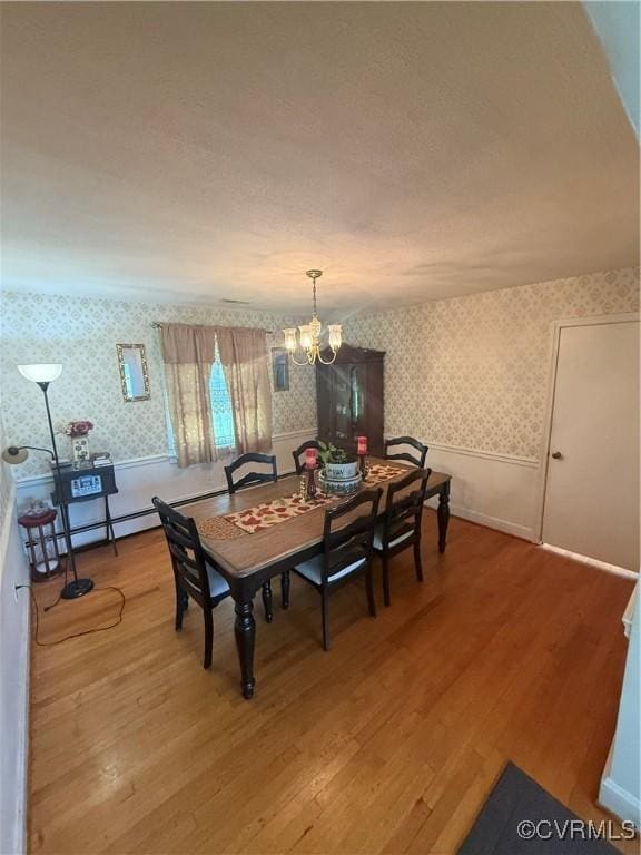 305 Danray Dr, Henrico, VA 23227 - dining area with wallpapered walls, a chandelier, wood finished floors, a wainscoted wall, and baseboard heating