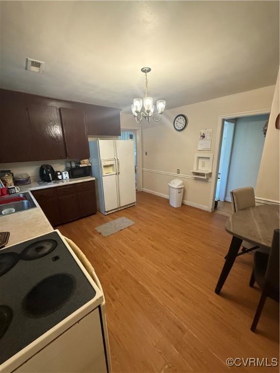305 Danray Dr, Henrico, VA 23227 - kitchen featuring white appliances, light wood-style flooring, dark brown cabinets, light countertops, and a chandelier