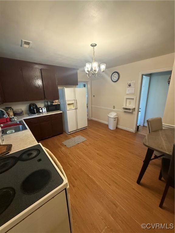 305 Danray Dr, Henrico, VA 23227 - kitchen featuring white refrigerator with ice dispenser, range, light wood finished floors, light countertops, and dark brown cabinets