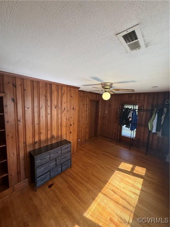 305 Danray Dr, Henrico, VA 23227 - unfurnished room featuring wood finished floors, a ceiling fan, a textured ceiling, and wood walls