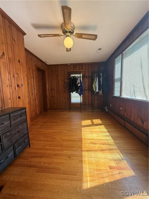 305 Danray Dr, Henrico, VA 23227 - empty room with light wood-style floors, a baseboard heating unit, wooden walls, and a ceiling fan