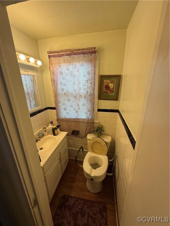 305 Danray Dr, Henrico, VA 23227 - half bathroom featuring tile walls, vanity, a textured ceiling, a wainscoted wall, and wood finished floors
