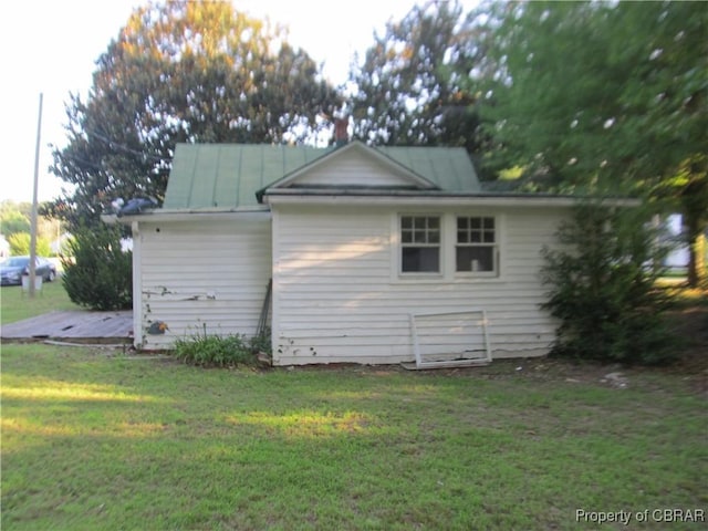 6847 Williams Landing Rd, Hayes, VA 23072 - view of side of home with a yard, a standing seam roof, and a metal roof