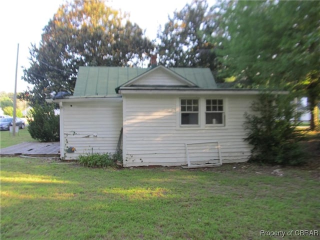 6847 Williams Landing Rd, Hayes, VA 23072 - view of side of property featuring a standing seam roof, a yard, and a metal roof