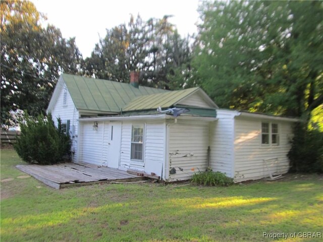 6847 Williams Landing Rd, Hayes, VA 23072 - rear view of house with a deck, a yard, a standing seam roof, and a chimney