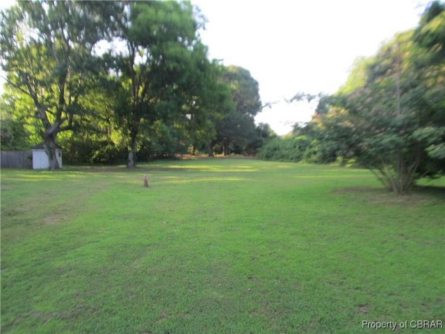 6847 Williams Landing Rd, Hayes, VA 23072 - view of green lawn featuring a storage unit and view of scattered trees