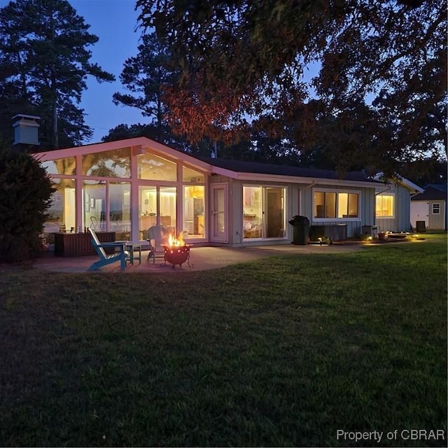 1583 Winona Park Dr, West Point, VA 23181 - back of house at dusk featuring a fire pit, board and batten siding, a yard, and a patio area