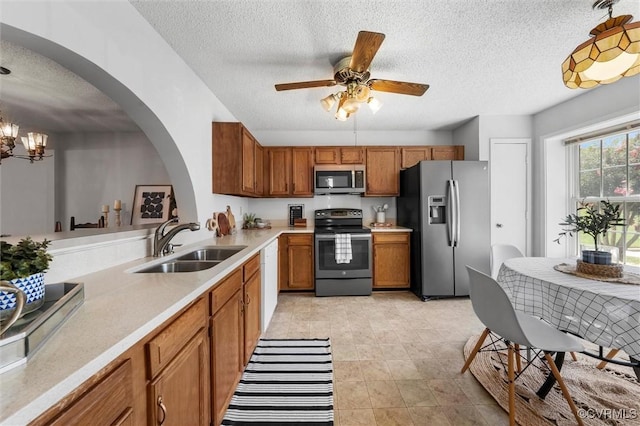 8015 Buford, North Chesterfield, VA 23235 - kitchen featuring appliances with stainless steel finishes, brown cabinetry, a textured ceiling, light countertops, and arched walkways