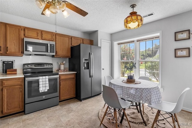 8015 Buford, North Chesterfield, VA 23235 - kitchen with stainless steel appliances, brown cabinets, light countertops, a textured ceiling, and a ceiling fan