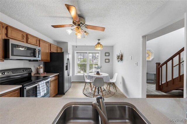 8015 Buford, North Chesterfield, VA 23235 - kitchen with stainless steel appliances, brown cabinets, light countertops, a ceiling fan, and a textured ceiling