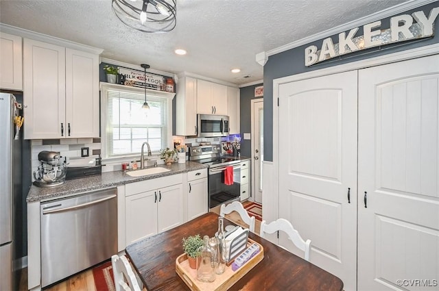 103 N Daisy Ave, Henrico, VA 23075 - kitchen with stainless steel appliances, a textured ceiling, ornamental molding, white cabinets, and recessed lighting