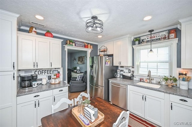 103 N Daisy Ave, Henrico, VA 23075 - kitchen featuring appliances with stainless steel finishes, white cabinetry, crown molding, a textured ceiling, and recessed lighting