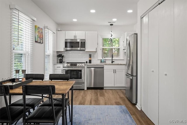 12305 Leesburg Cir, Midlothian, VA 23112 - kitchen with stainless steel appliances, wood finished floors, white cabinetry, tasteful backsplash, and recessed lighting