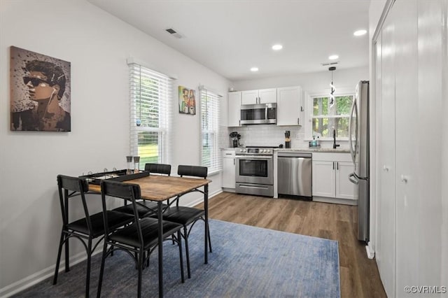 12305 Leesburg Cir, Midlothian, VA 23112 - kitchen with stainless steel appliances, wood finished floors, white cabinetry, recessed lighting, and light countertops