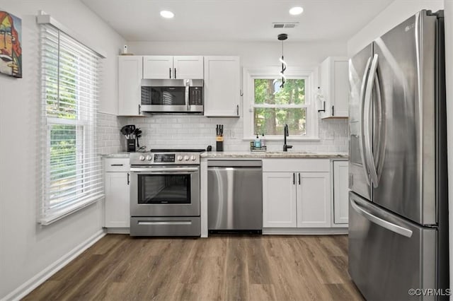 12305 Leesburg Cir, Midlothian, VA 23112 - kitchen with stainless steel appliances, dark wood finished floors, white cabinets, tasteful backsplash, and light stone counters