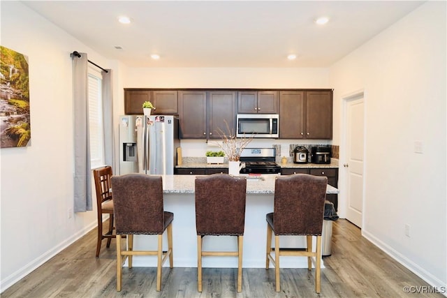 6431 Faulkner Dr, North Chesterfield, VA 23234 - kitchen featuring stainless steel appliances, dark brown cabinetry, an island with sink, light wood finished floors, and recessed lighting