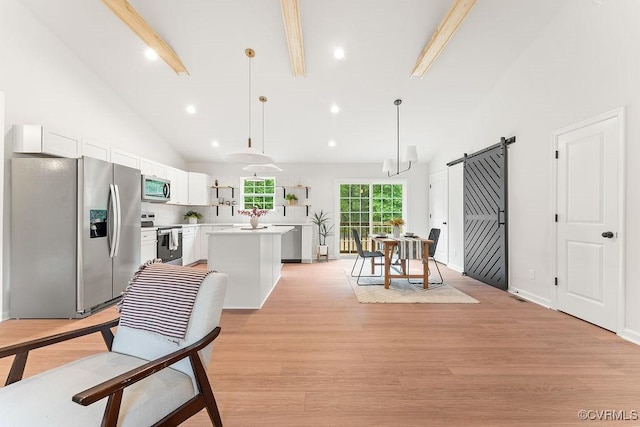 26354 Old Pitts, Ruther Glen, VA 22546 - kitchen featuring stainless steel appliances, a barn door, a center island, light wood-style floors, and white cabinets