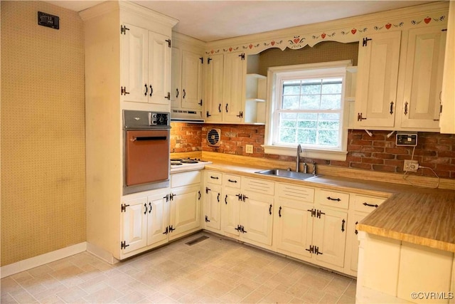 1208 Amesbury Ln, Richmond, VA 23227 - kitchen with oven, under cabinet range hood, light countertops, tasteful backsplash, and wallpapered walls