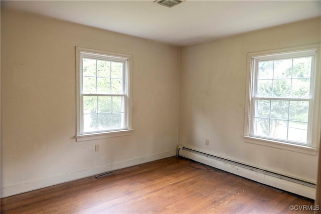 1208 Amesbury Ln, Richmond, VA 23227 - empty room with a baseboard heating unit, healthy amount of natural light, and wood finished floors