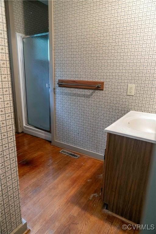 1208 Amesbury Ln, Richmond, VA 23227 - full bath featuring wood finished floors, vanity, a shower stall, and wallpapered walls