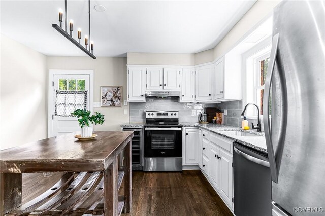 8101 Lake Shore Dr, North Chesterfield, VA 23235 - kitchen with appliances with stainless steel finishes, light stone countertops, under cabinet range hood, and white cabinetry