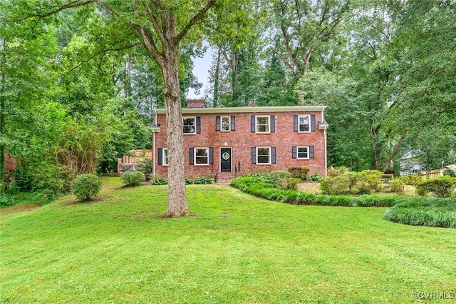 8101 Lake Shore Dr, North Chesterfield, VA 23235 - colonial house featuring a front lawn, a chimney, and brick siding