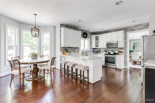 1240 Miners Trail Rd, Midlothian, VA 23114 - kitchen with appliances with stainless steel finishes, a peninsula, light countertops, dark wood-style flooring, and white cabinets