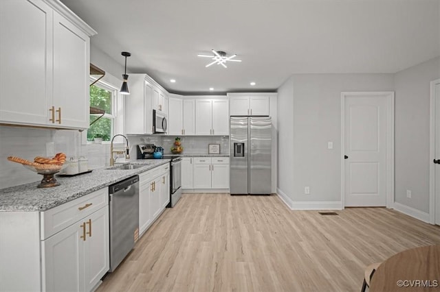 2227 S Whitehill Dr, Petersburg, VA 23803 - kitchen with appliances with stainless steel finishes, tasteful backsplash, light wood-type flooring, white cabinets, and recessed lighting