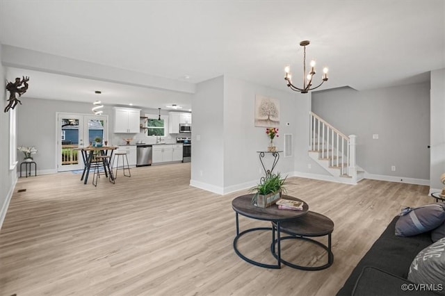 2227 S Whitehill Dr, Petersburg, VA 23803 - living area featuring light wood-style flooring, a chandelier, and stairs