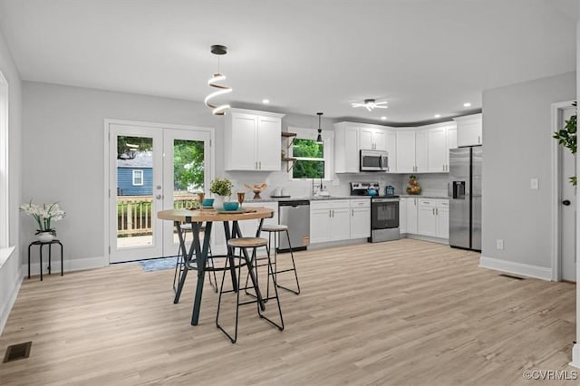 2227 S Whitehill Dr, Petersburg, VA 23803 - kitchen featuring stainless steel appliances, light wood-style flooring, decorative backsplash, white cabinets, and recessed lighting