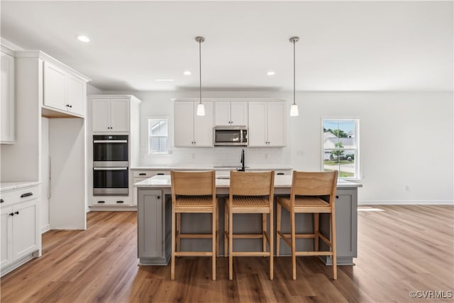 9130 Terroir Ln, New Kent, VA 23124 - kitchen featuring stainless steel appliances, light wood-style floors, healthy amount of natural light, decorative backsplash, and recessed lighting