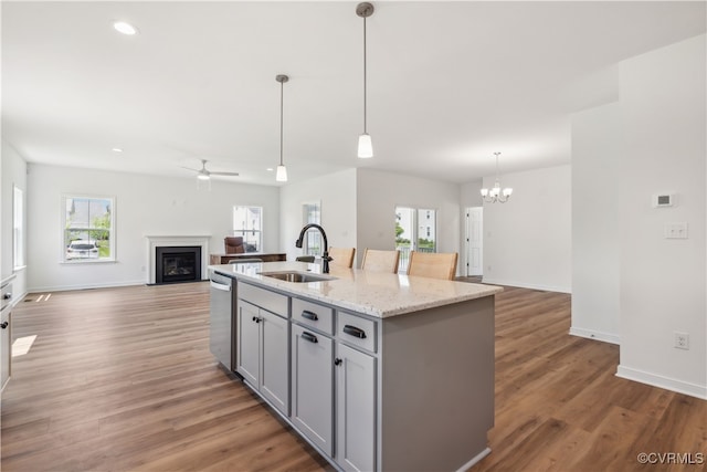 9130 Terroir Ln, New Kent, VA 23124 - kitchen with a glass covered fireplace, ceiling fan, open floor plan, gray cabinetry, and a chandelier