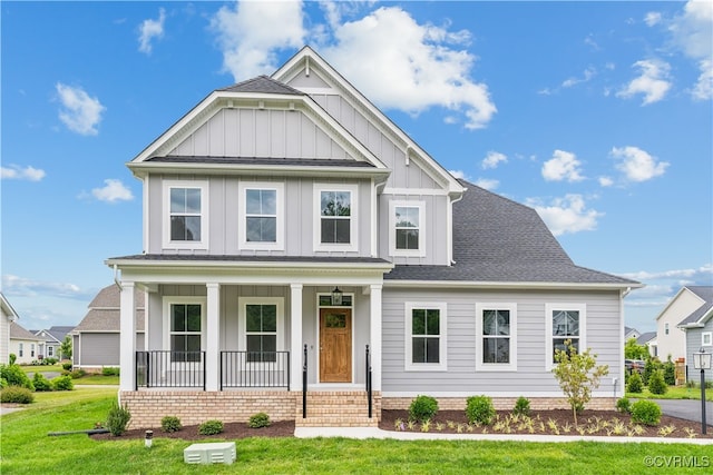 9130 Terroir Ln, New Kent, VA 23124 - view of front facade featuring board and batten siding, covered porch, a front yard, and a shingled roof