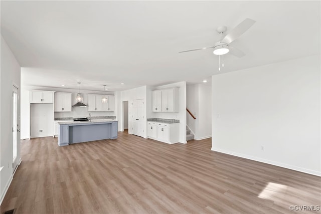 9131 Terroir Ln, New Kent, VA 23124 - unfurnished living room featuring light wood-style flooring, a ceiling fan, stairs, and recessed lighting