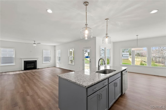9131 Terroir Ln, New Kent, VA 23124 - kitchen with dishwasher, gray cabinetry, a ceiling fan, light stone counters, and wood finished floors
