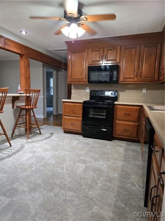 2707 Academy Rd, Powhatan, VA 23139 - kitchen featuring black appliances, a ceiling fan, brown cabinetry, and light countertops