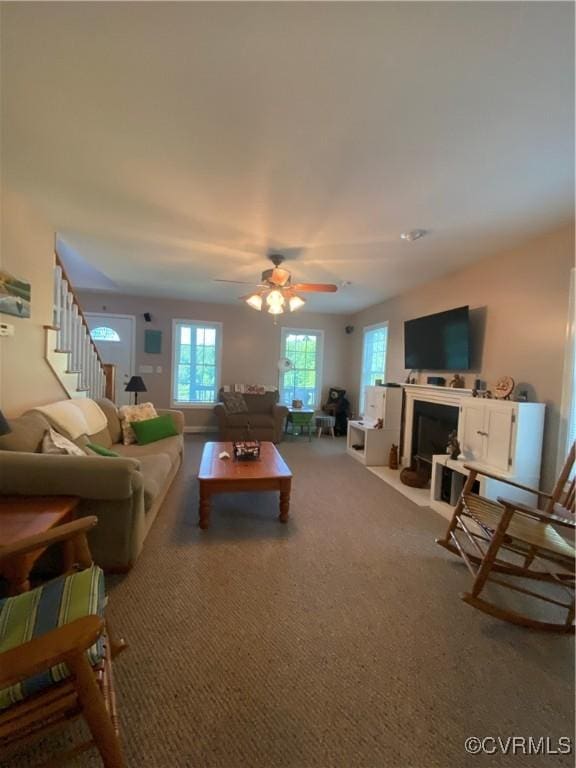 4554 Plank Rd, Kenbridge, VA 23944 - carpeted living room featuring ceiling fan, stairs, and a fireplace with flush hearth