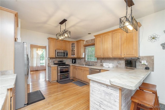 13813 Bluff Ridge Dr, Chesterfield, VA 23838 - kitchen with appliances with stainless steel finishes, light wood-type flooring, a peninsula, and a kitchen bar