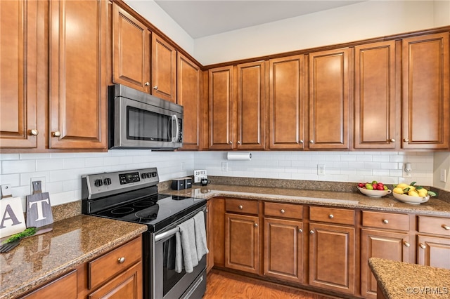 5915 E Stonepath Garden Dr, Chester, VA 23831 - kitchen with appliances with stainless steel finishes, brown cabinetry, decorative backsplash, and dark stone countertops