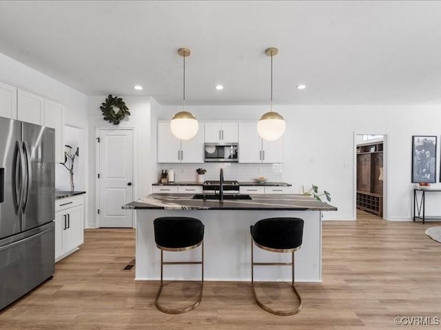 9913 Craftsbury Dr, Midlothian, VA 23112 - kitchen featuring stainless steel appliances, decorative backsplash, a breakfast bar area, white cabinetry, and recessed lighting