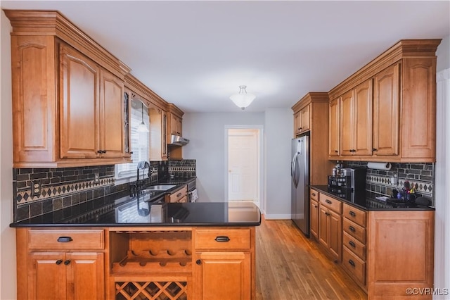 12703 Kelsey Pointe Ct, Chester, VA 23831 - kitchen featuring freestanding refrigerator, light wood-style flooring, decorative backsplash, a peninsula, and under cabinet range hood