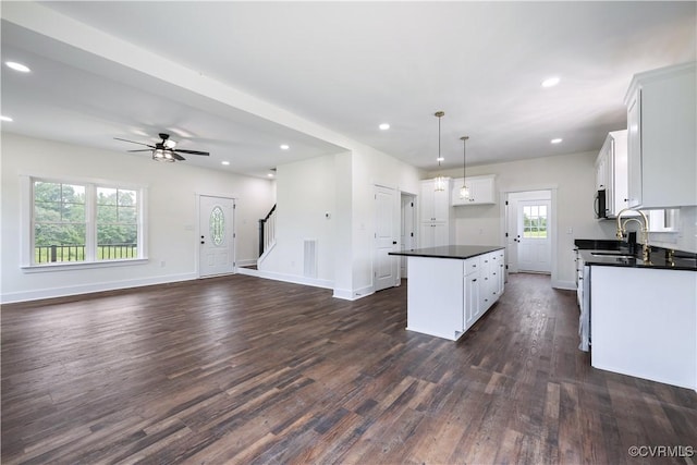 1175 Anderson Hwy, Cumberland, VA 23040 - kitchen featuring dark countertops, dark wood-style floors, a kitchen island, white cabinetry, and open floor plan