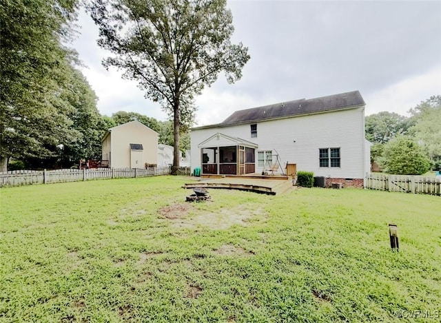 7016 Narragansett Ct, Hanover, VA 23111 - rear view of house featuring a sunroom, a wooden deck, a fenced backyard, and an outdoor fire pit