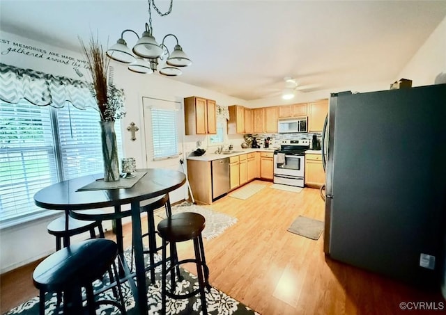 7016 Narragansett Ct, Hanover, VA 23111 - kitchen featuring appliances with stainless steel finishes, light wood finished floors, a chandelier, light countertops, and a ceiling fan